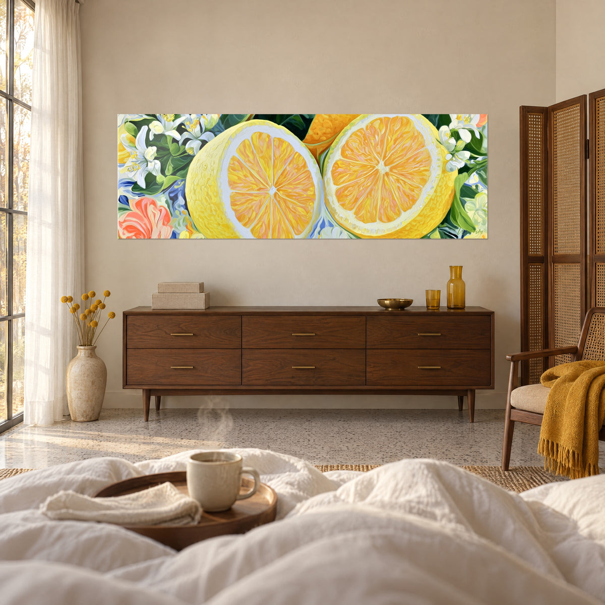 Wall art of twin halved lemons with golden pulp, white petals and blue accents, above a bed in a light bedroom