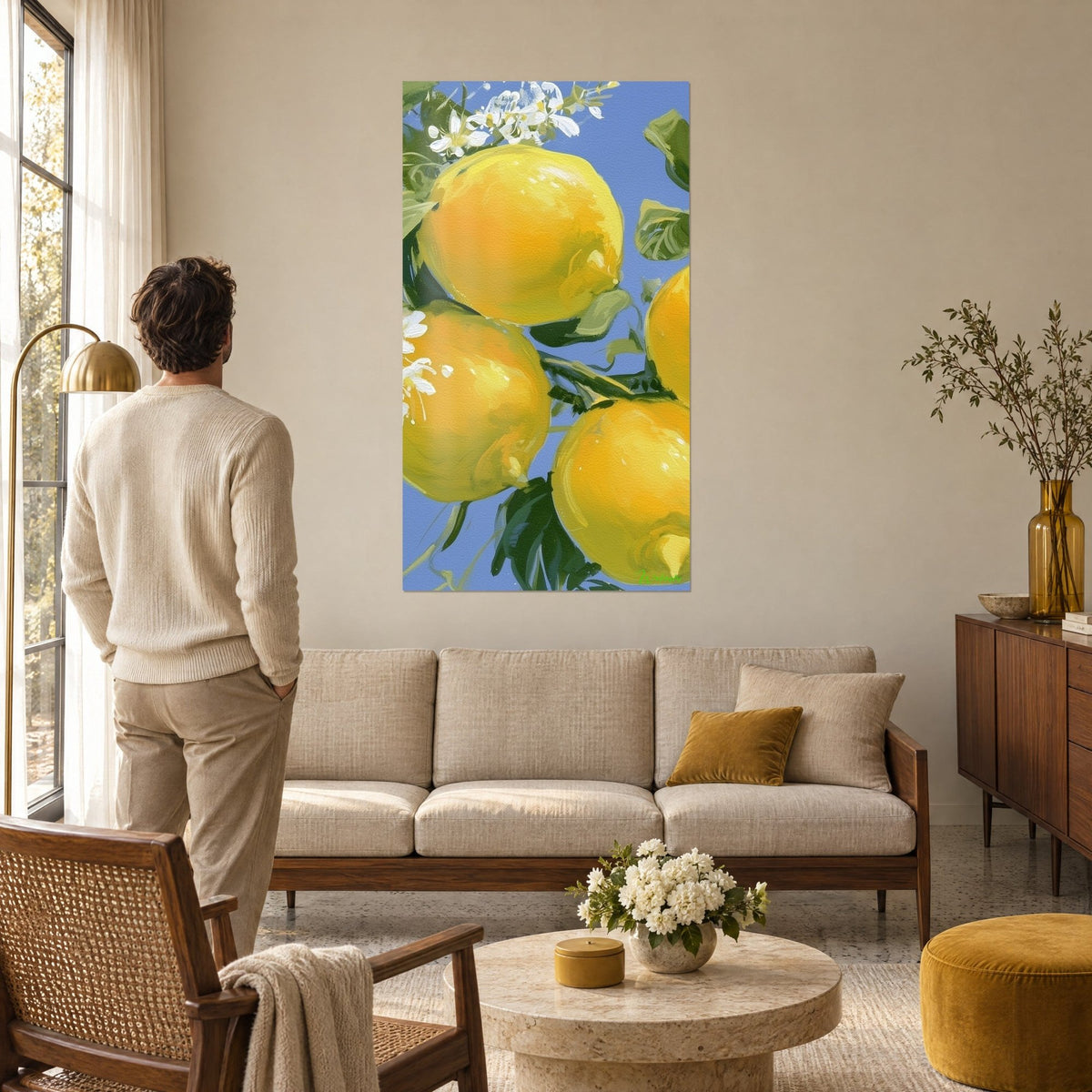 Tableau quatre agrumes dorés sur fond bleu ciel, fleurs blanches, homme de dos au-dessus d'un canapé dans un salon lumineux
