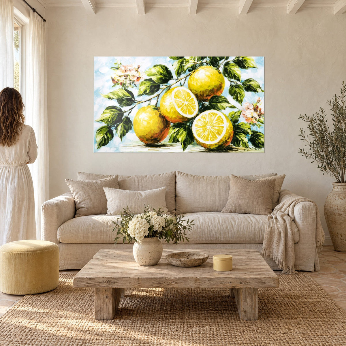 Tableau citrons dorés sur leur branche fleurie, feuillage vert sombre et fond bleu ciel, au-dessus d'un canapé dans un salon lumineux
