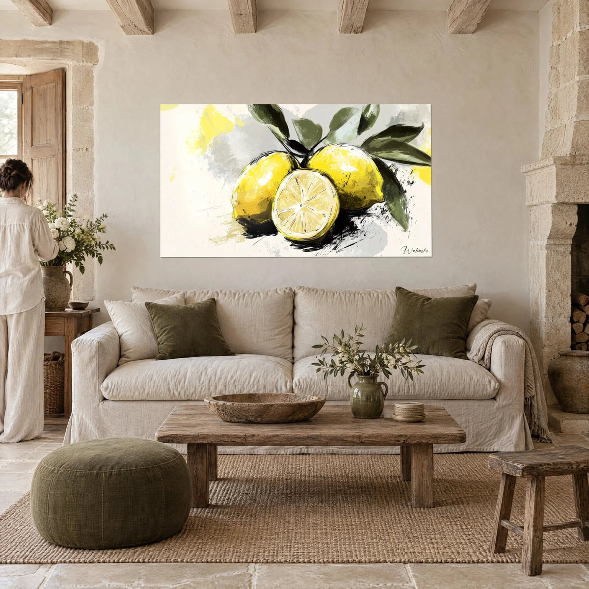 Schilderij citroenen in felgeel en één doormidden gesneden, olijfgroene bladeren, crèmekleurige achtergrond, vrouw van achteren, boven een bank in een lichte woonkamer