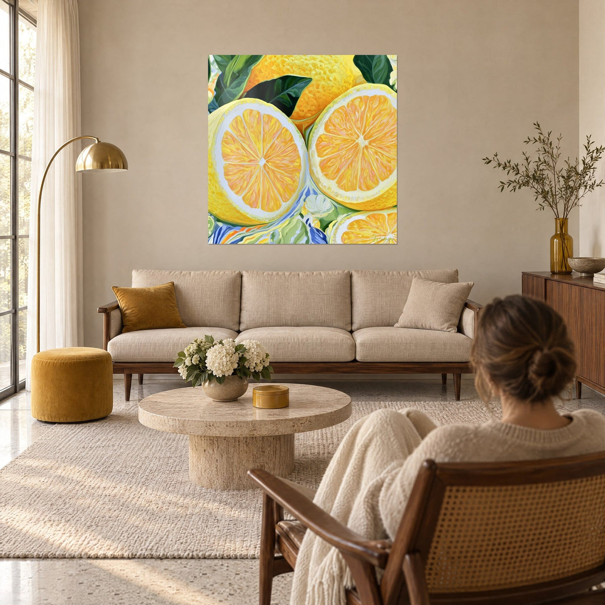 Tableau citrons coupés en deux, chair orange rayonnante et écorce jaune, feuilles vertes, femme de dos au-dessus d'un canapé dans un salon lumineux