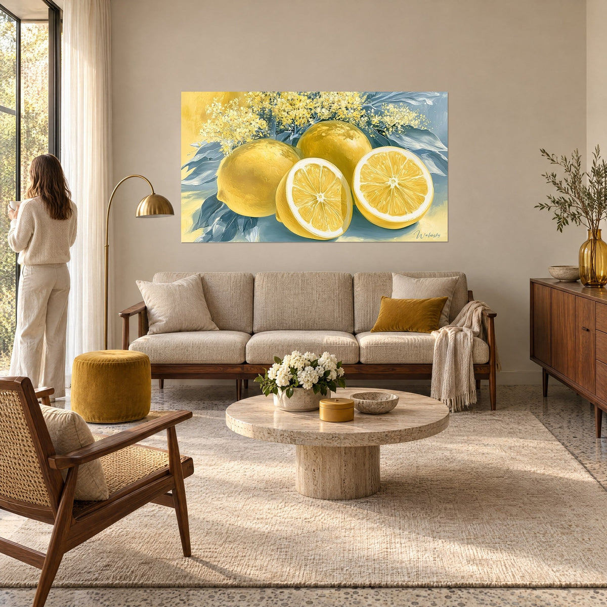Tableau citrons dorés et fleurs de mimosa sur feuillage bleu pâle, une femme de dos, au-dessus d'un canapé dans un salon lumineux