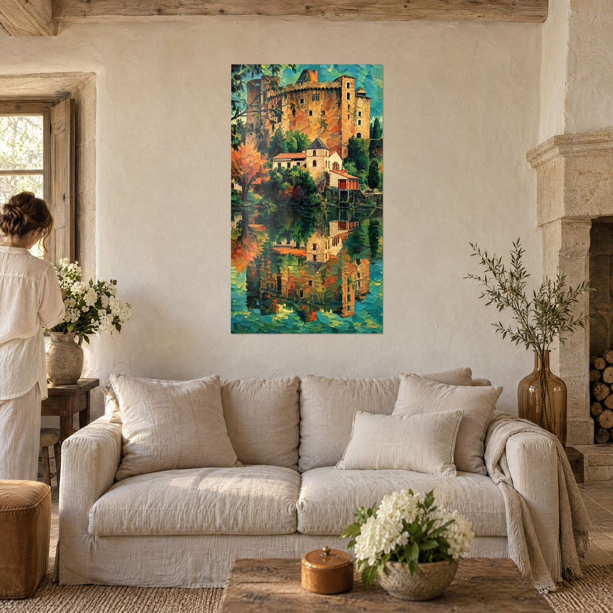 Quadro castello medievale in ocra e arancio riflesso in acqua turchese, donna di spalle, sopra un divano in un soggiorno luminoso