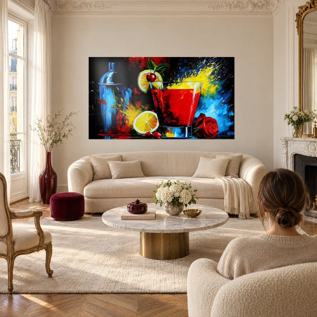 Tableau cocktail rouge vif orné d'une cerise, éclaboussures jaunes et bleues sur fond noir, au-dessus d'un canapé dans un salon lumineux