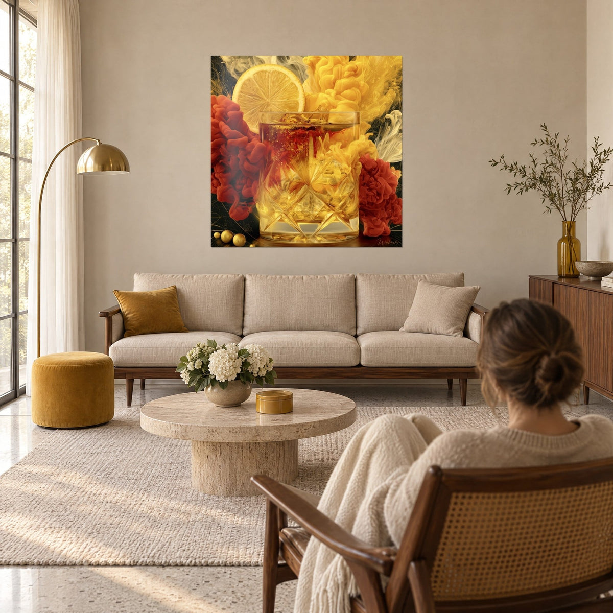 Tableau whisky dans un verre ciselé baigné d'or, volutes rouges et jaunes, devant une femme de dos, au-dessus d'un canapé dans un salon lumineux
