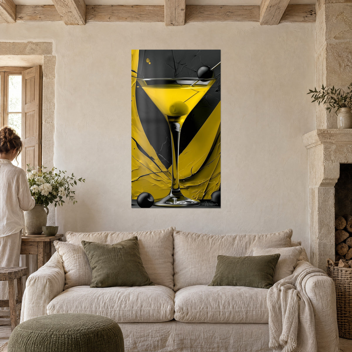 Quadro coppa da martini giallo limone su sfondo nero, oliva sospesa, una persona di spalle, sopra un divano in un soggiorno luminoso