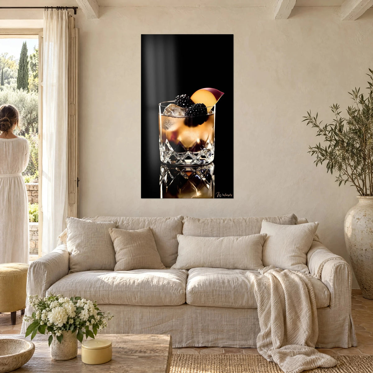 Tableau cocktail ambré sur glaçon, mûres et quartier de pêche, fond noir, au-dessus d'un canapé dans un salon lumineux
