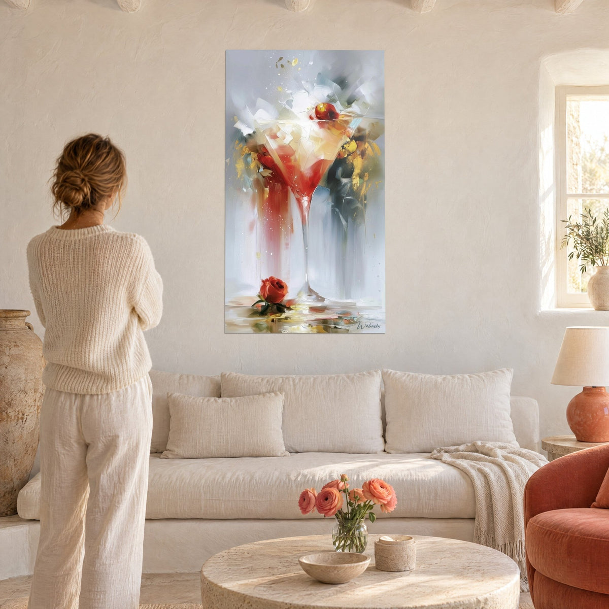 Cuadro copa de cóctel con goteos rojos y toques dorados, mujer de espaldas, sobre un sofá en un salón luminoso