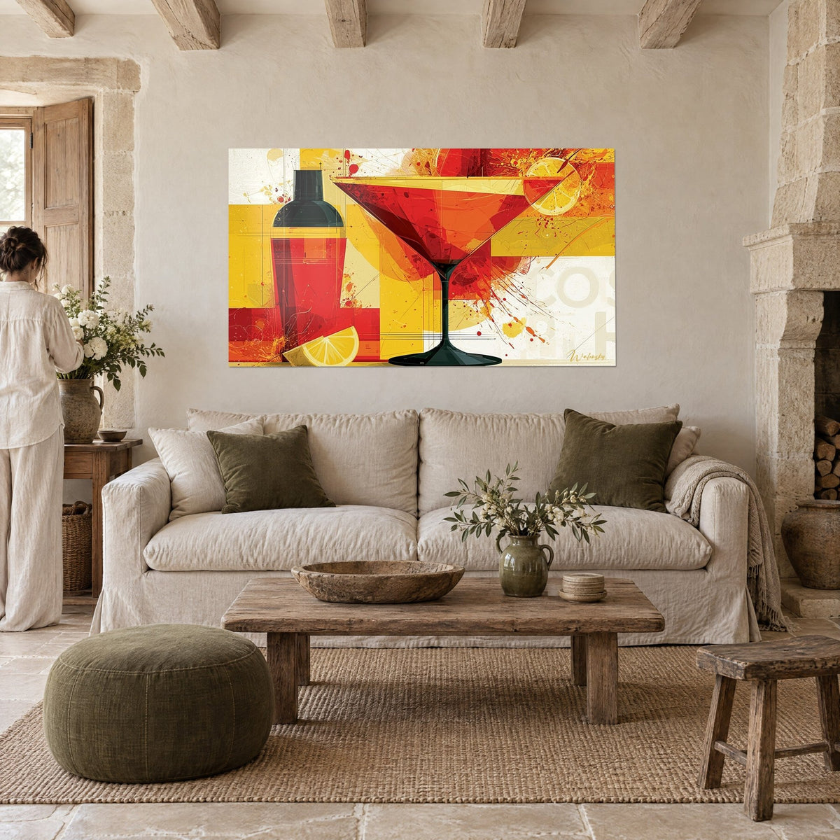 Tableau martini rouge éclaboussé de jaune, shaker noir et citron, femme de dos au-dessus d'un canapé dans un salon lumineux