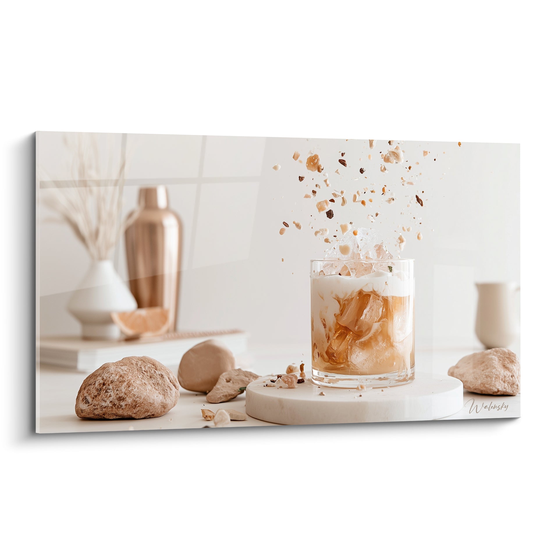 Verre à cocktail ambré et beige avec éclats dorés suspendus dans les airs sur fond crème