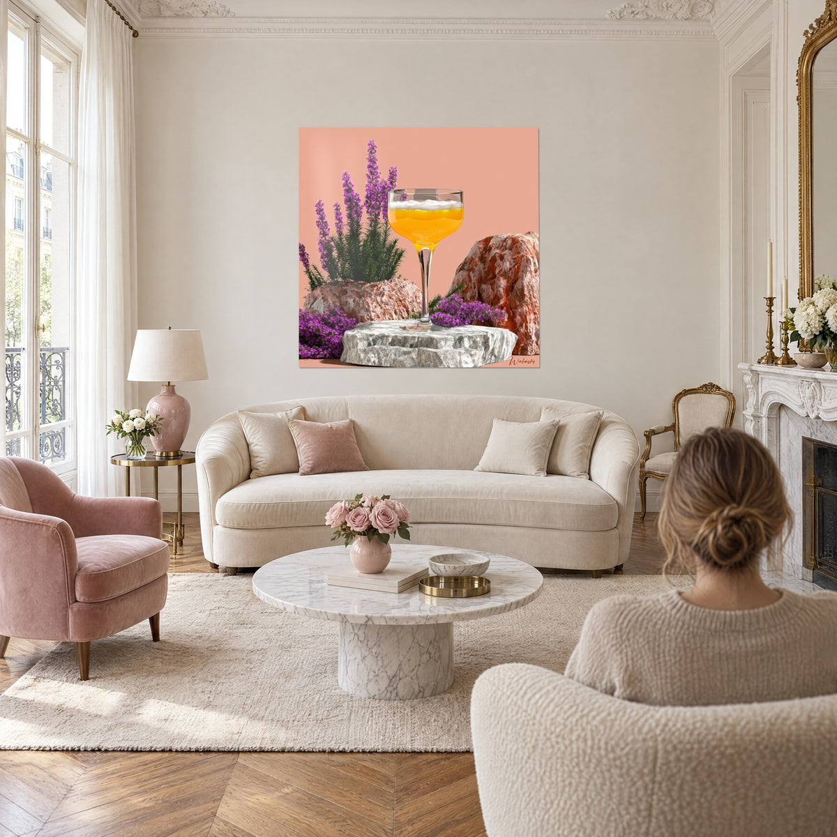 Gemälde Cocktailglas orange mit Schaumkrone auf lachsfarbenem Grund, lila Heidekraut und rostrote Felsen, über einem Sofa in einem hellen Wohnzimmer