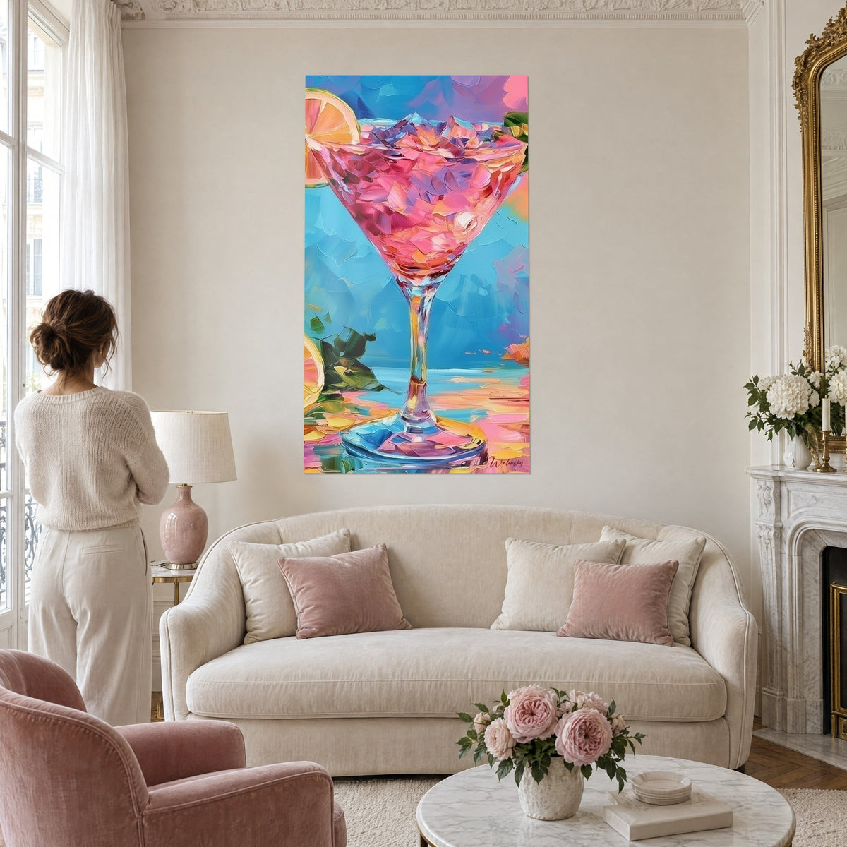 Gemälde Cocktailglas Rosa Blase, orangefarbene Zitronenscheiben auf türkisem Hintergrund, Frau von hinten, über einem Sofa in einem hellen Wohnzimmer