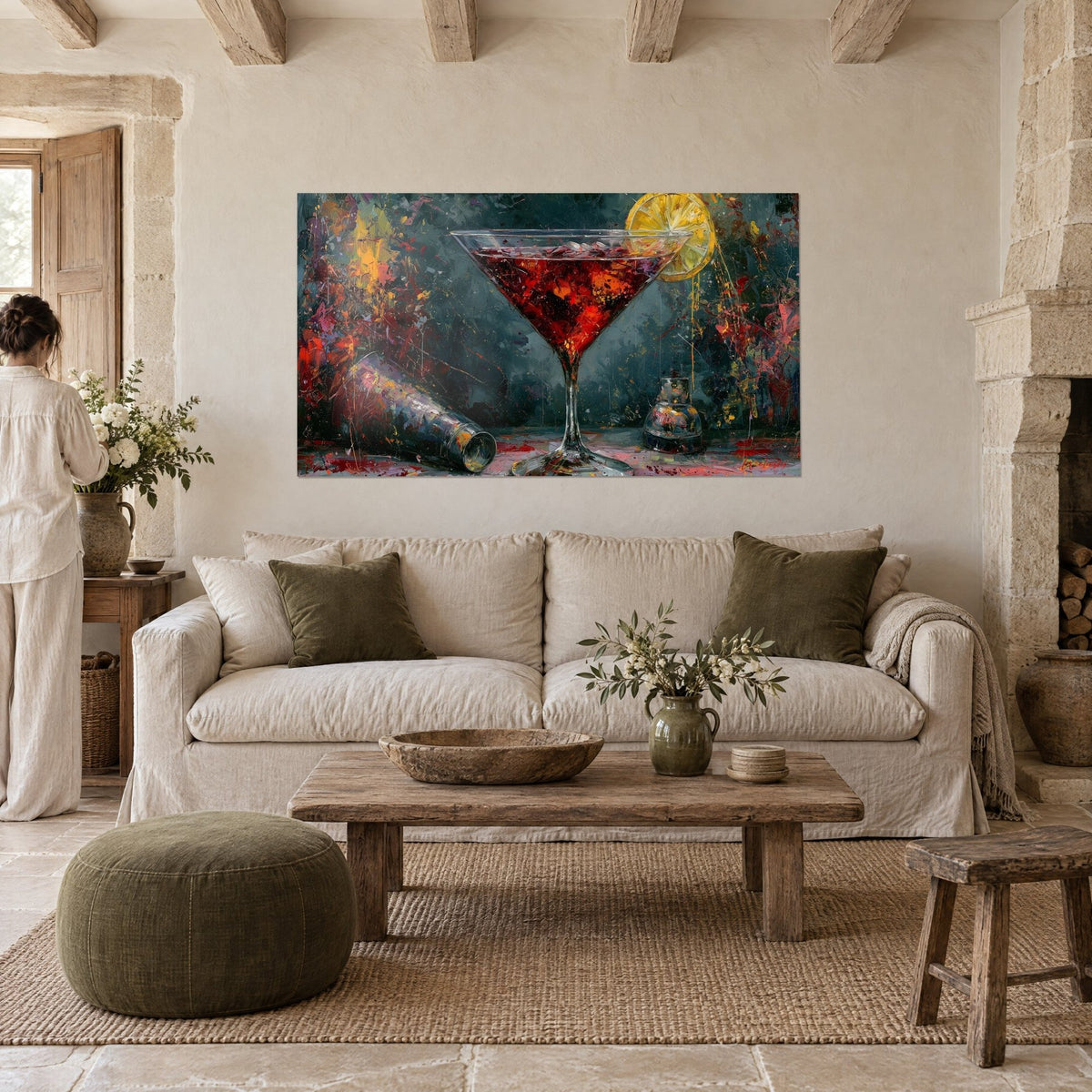 Tableau coupe à martini rouge grenat, tranche de citron jaune et shaker argenté couché, au-dessus d'un canapé dans un salon lumineux