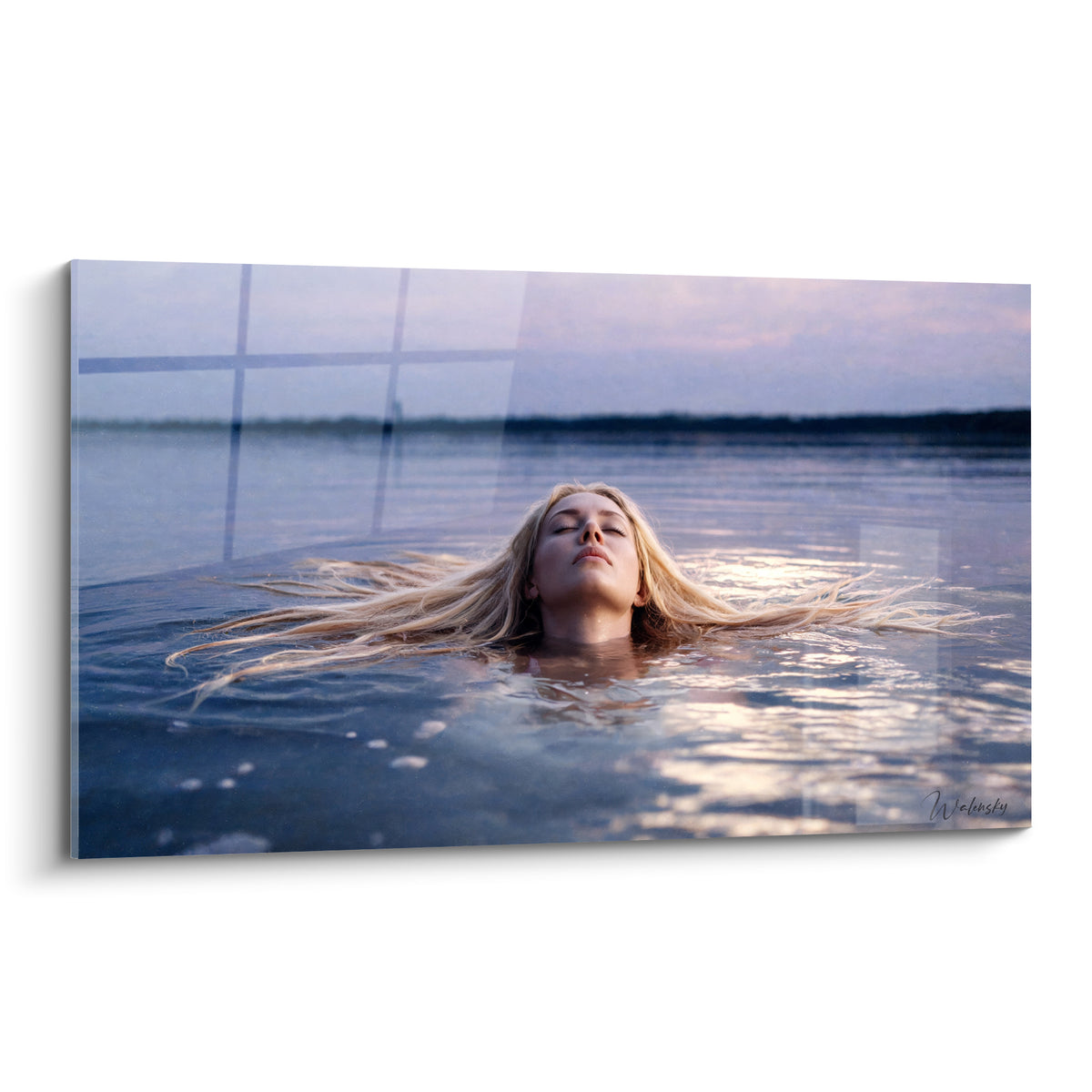 Chevelure blonde étalée sur eau bleu lavande, visage serein aux yeux clos, lumière crépusculaire dorée