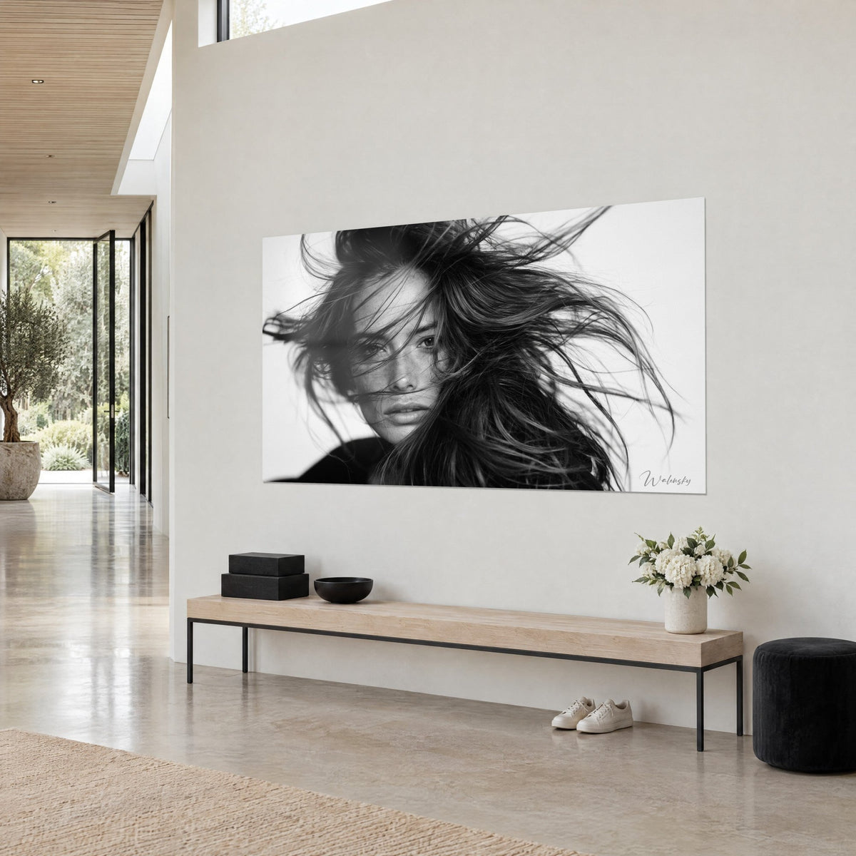 Wall art face with freckles, brown hair tousled by the wind, deep black and pure white, beige wall of an architect's home