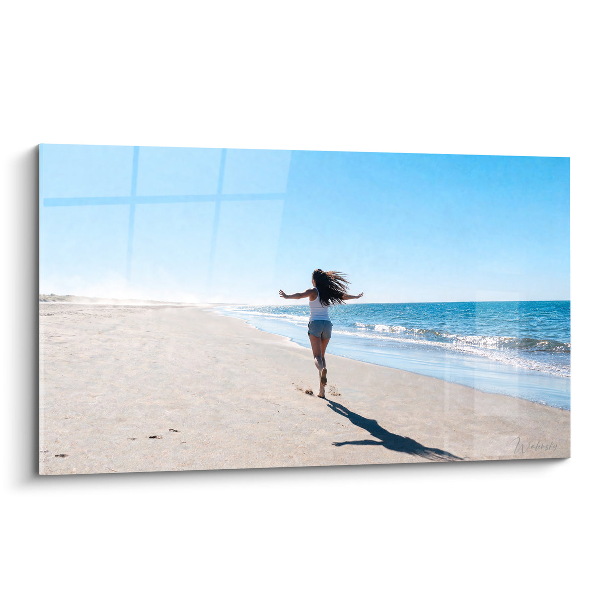Tableau silhouette féminine courant sur une plage de sable beige, ciel bleu et vagues turquoise en fond