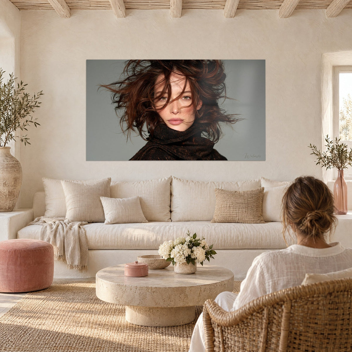 Cuadro retrato femenino con mechones castaños sopla dos al viento, ojos verdes, bufanda marrón, encima de un sofá en un salón luminoso