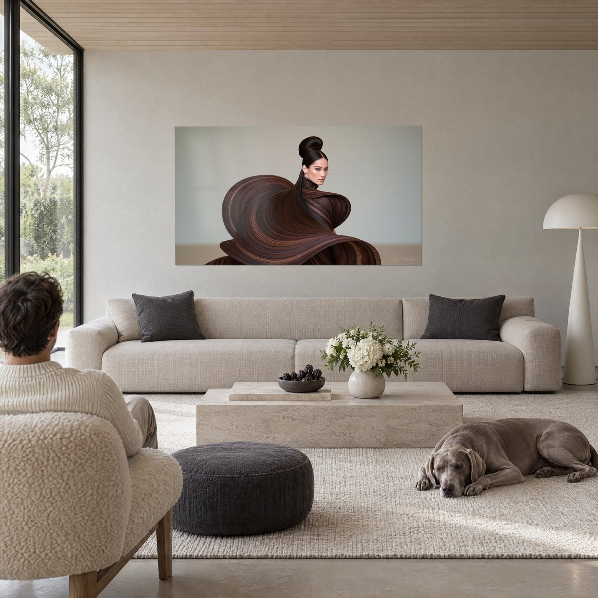 Wall art of a mannequin with a high bun in a wavy brown cape, grey-blue background, hung above a sofa in a bright living room