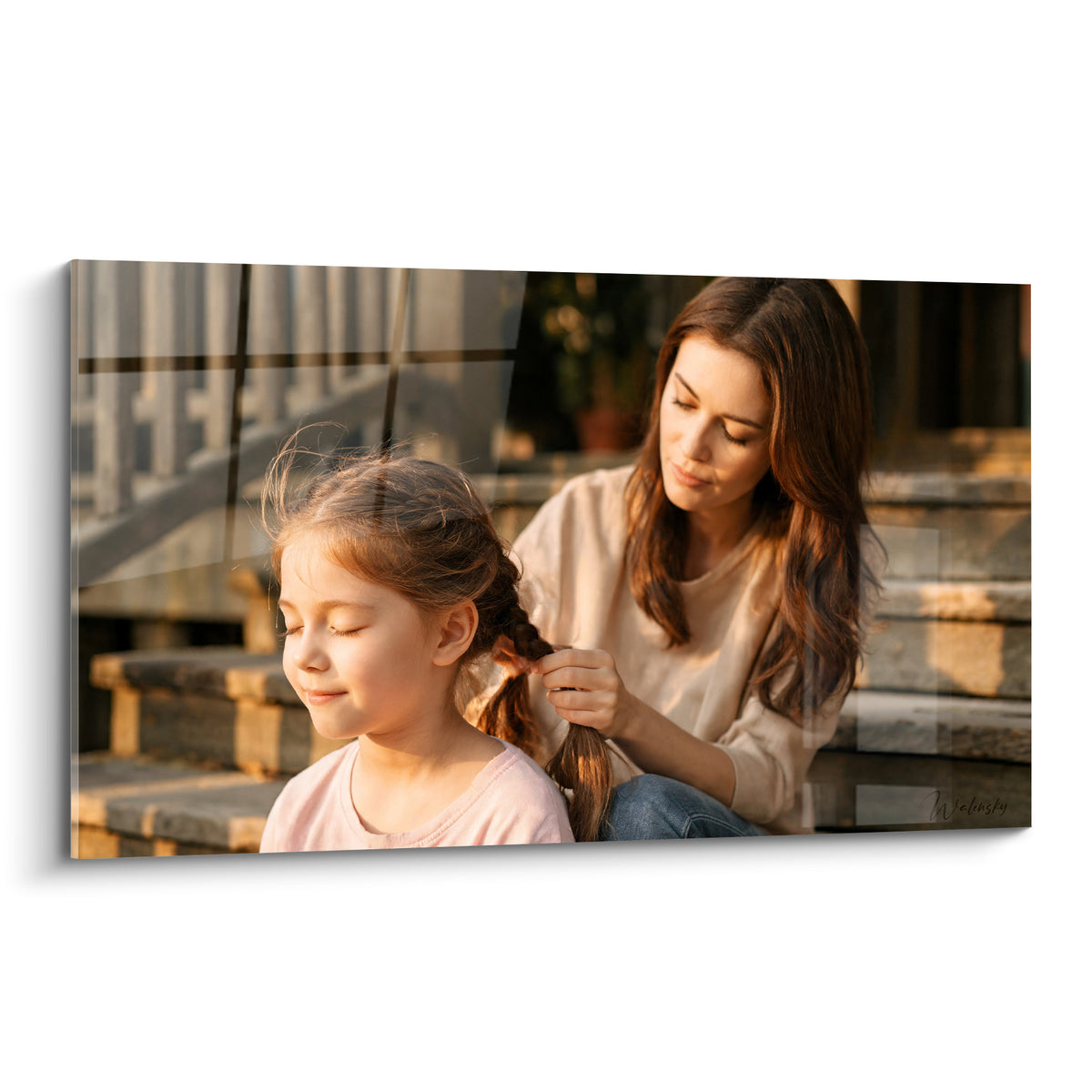 Mère aux cheveux bruns tressant les mèches rousses de sa fille, lumière dorée et tons beige au coucher du soleil