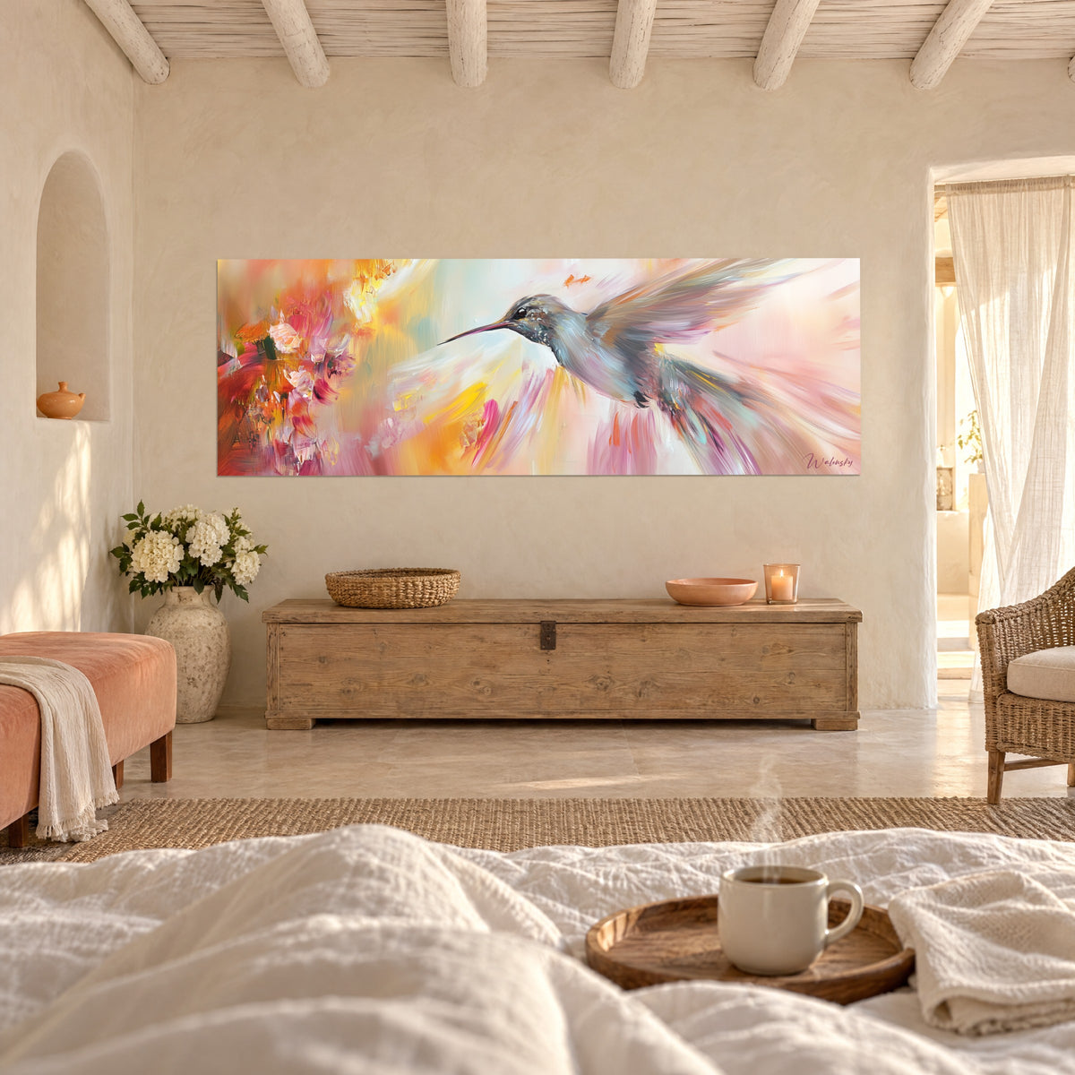 Wall art small hummingbird in full flight, blue-grey plumage over orange and powder pink highlights, above a bed in a light bedroom