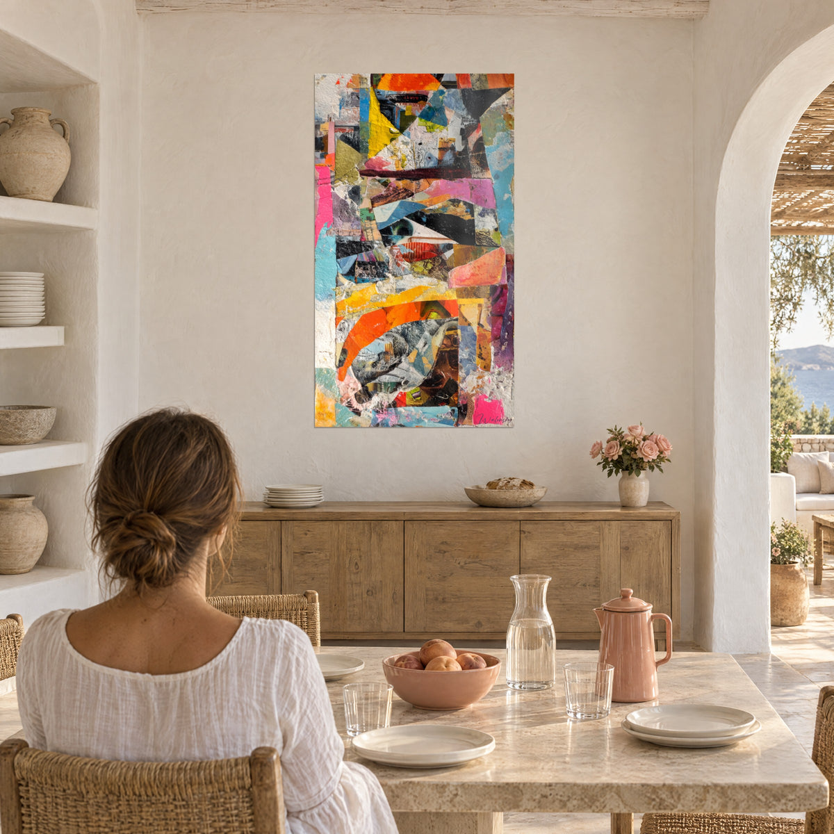 Cuadro composición de papeles superpuestos azul cielo, magenta y naranja quemado, mujer de espaldas en una mesa, pared de yeso blanco, arco abovedado