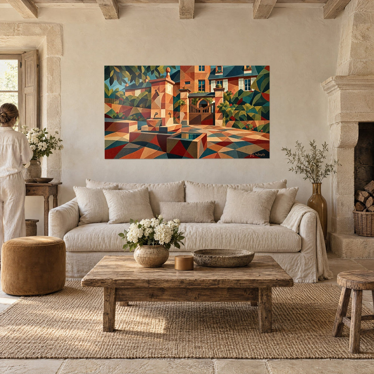 Wall art stone fountain in ochre and faceted petrol-blue facades, a woman seen from behind, above a sofa in a bright living room