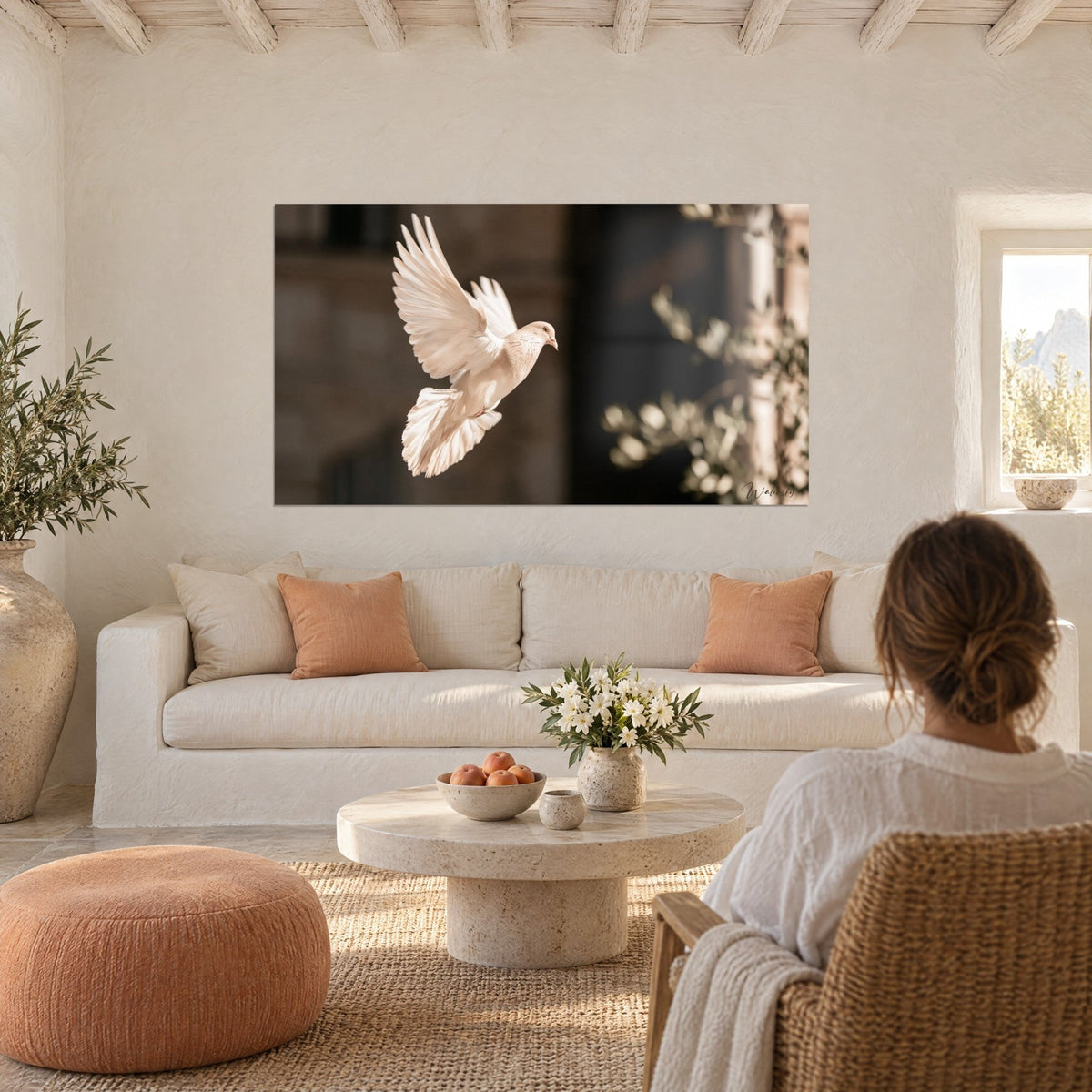 Cuadro paloma blanca con las alas desplegadas, plumas crema sobre fondo marrón y rama de olivo, encima de un sofá en un salón luminoso