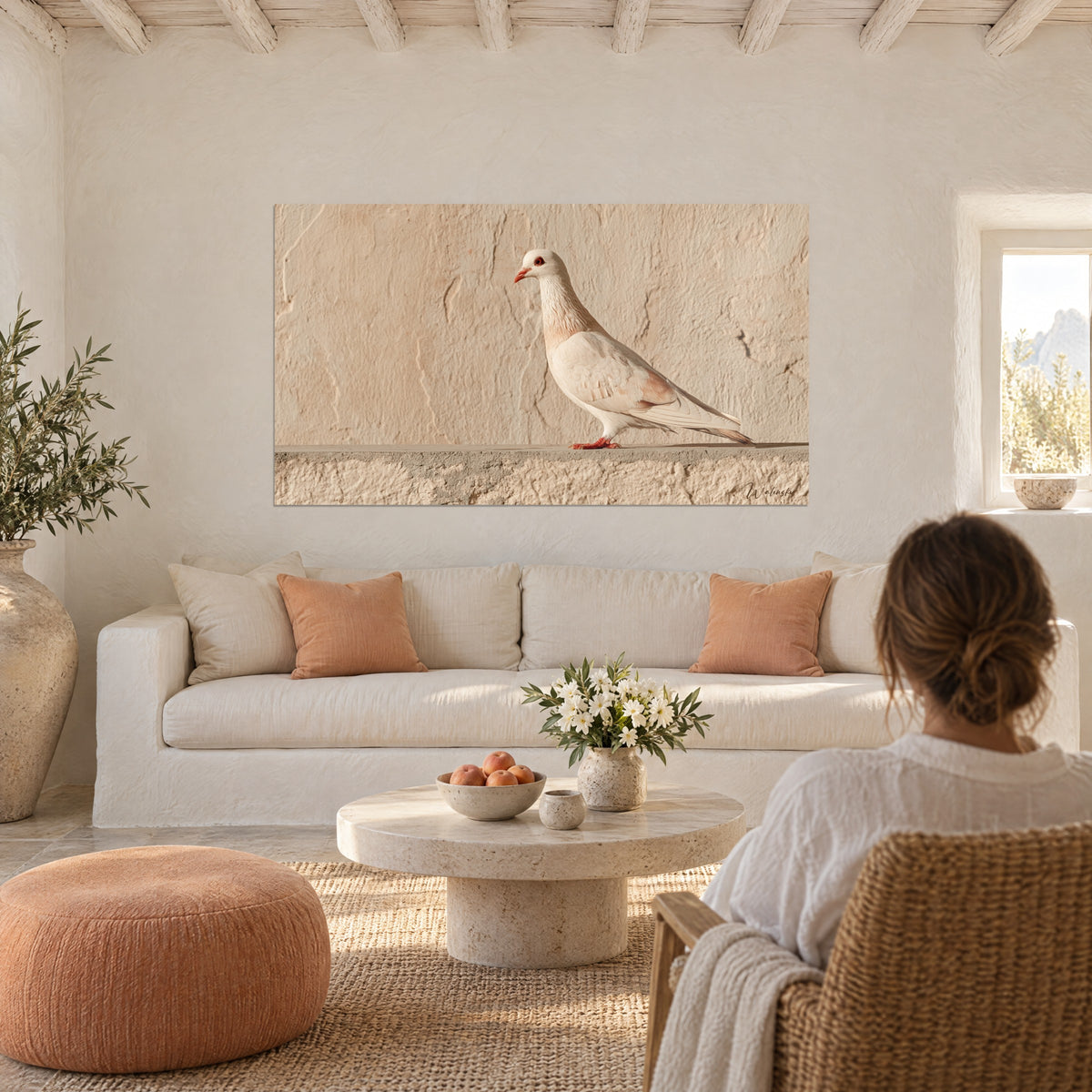 Tableau colombe blanche au bec corail, perchée sur un muret beige, accrochée au-dessus d'un canapé dans un salon lumineux