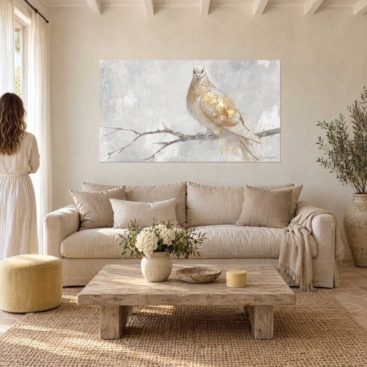 Tableau colombe au plumage blanc rehaussé de feuilles d'or sur branche nue, gris perle, au-dessus d'un canapé dans un salon lumineux