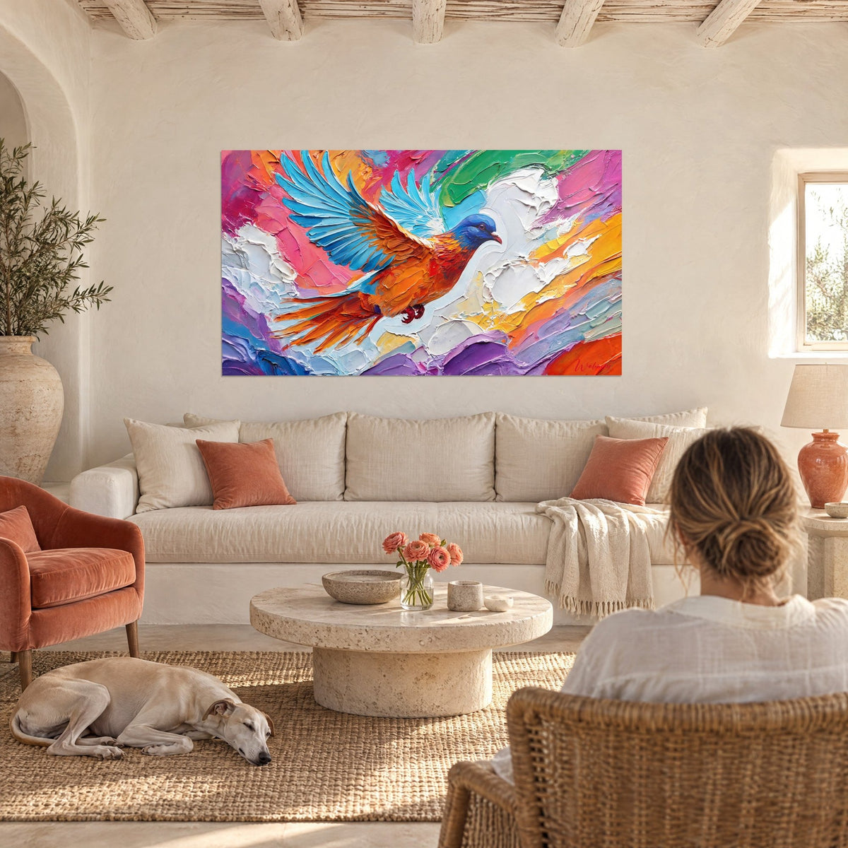 Cuadro paloma naranja de alas azul cielo, empastes de pintura rosa y blanca, sobre un sofá en un salón luminoso