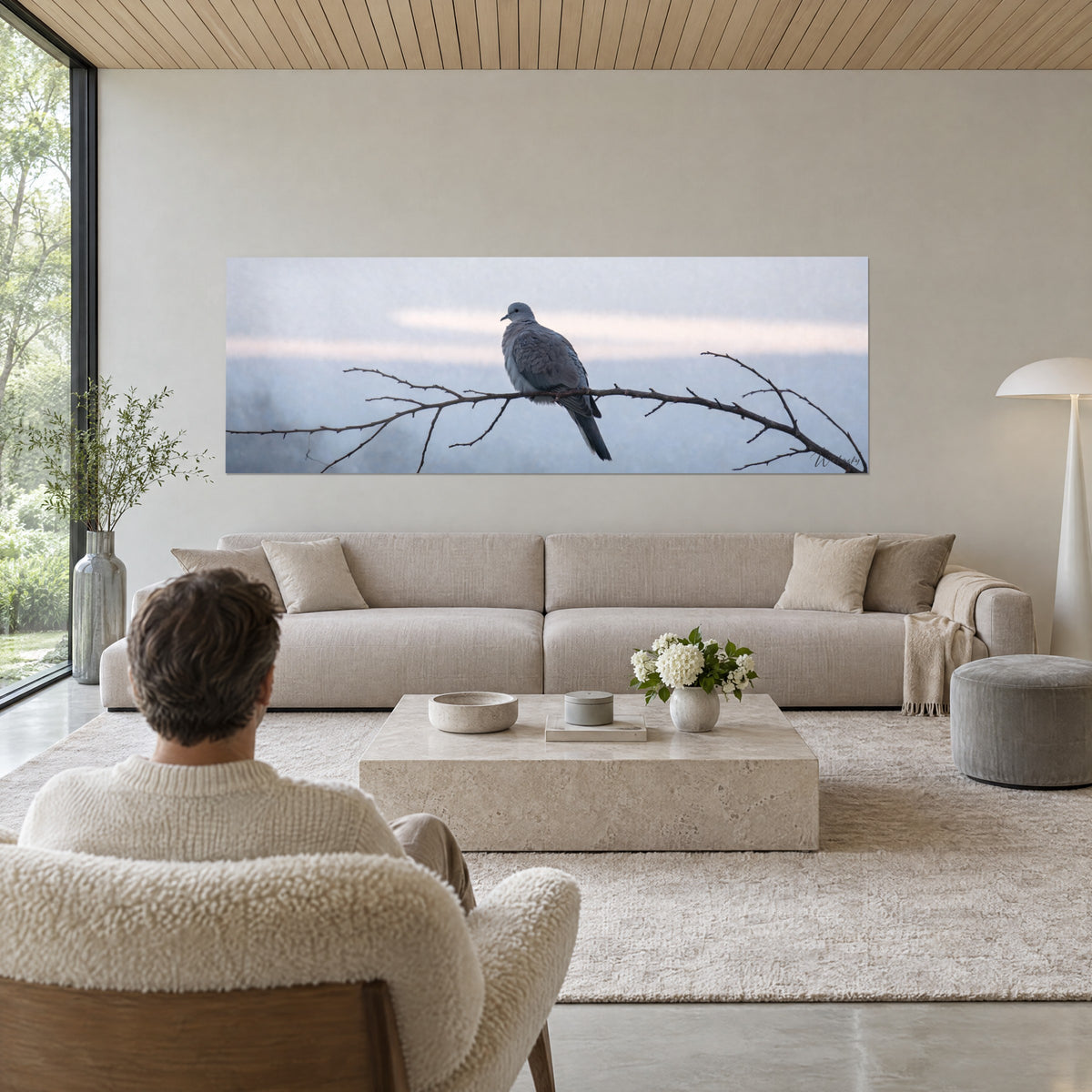 Gemälde Taube in Grau auf einem kahlen Ast sitzend, blaugrauer Himmel mit einem blassrosa Streifen, über einem Sofa in einem hellen Wohnzimmer