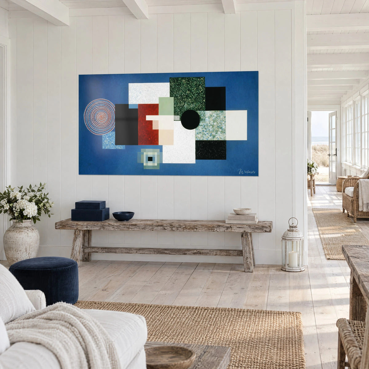 Cuadro mosaico de bloques negros, blancos y verde salvia, espiral roja punteada a la izquierda, sobre la pared blanca de una casa junto al mar