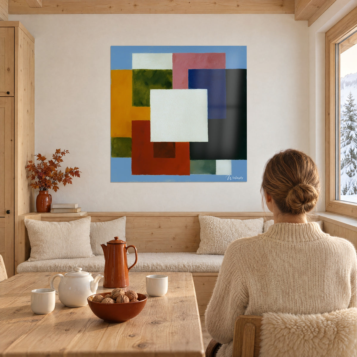 Cuadro juego de bloques de colores, azul marino, naranja azafrán y rosa empolvado alrededor de un cuadrado crema, frente a una mesa de madera