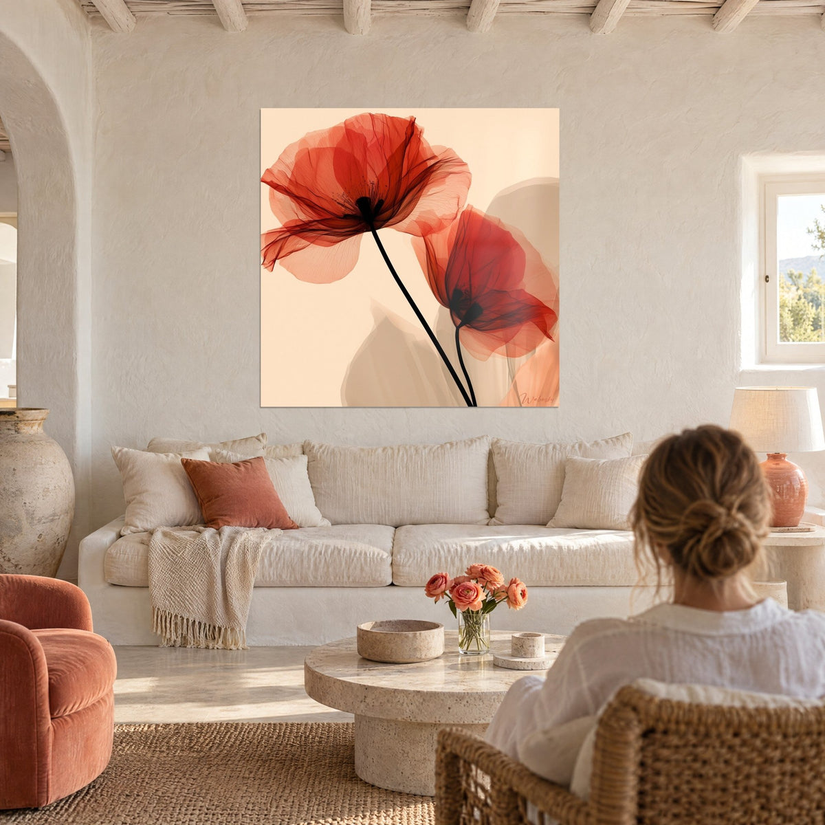 Tableau coquelicots rouges translucides sur fond crème, pétales diaphanes et tiges noires, femme de dos, au-dessus d'un canapé dans un salon lumineux
