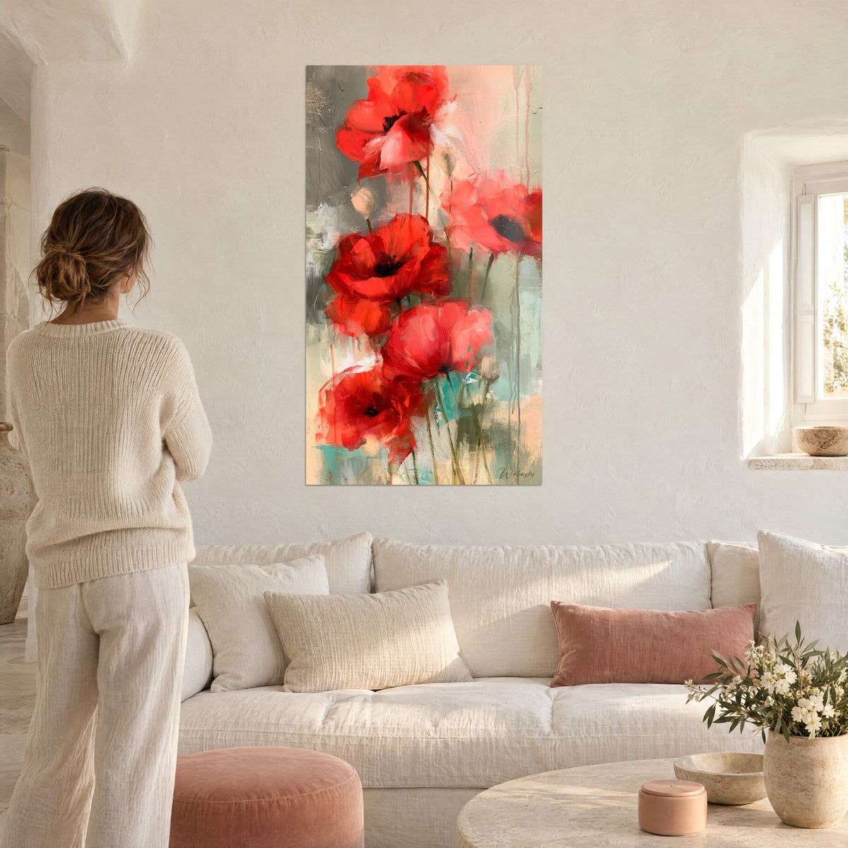 Tableau coquelicots écarlates aux pétales froissés, fond gris et beige, femme de dos, au-dessus d'un canapé dans un salon lumineux