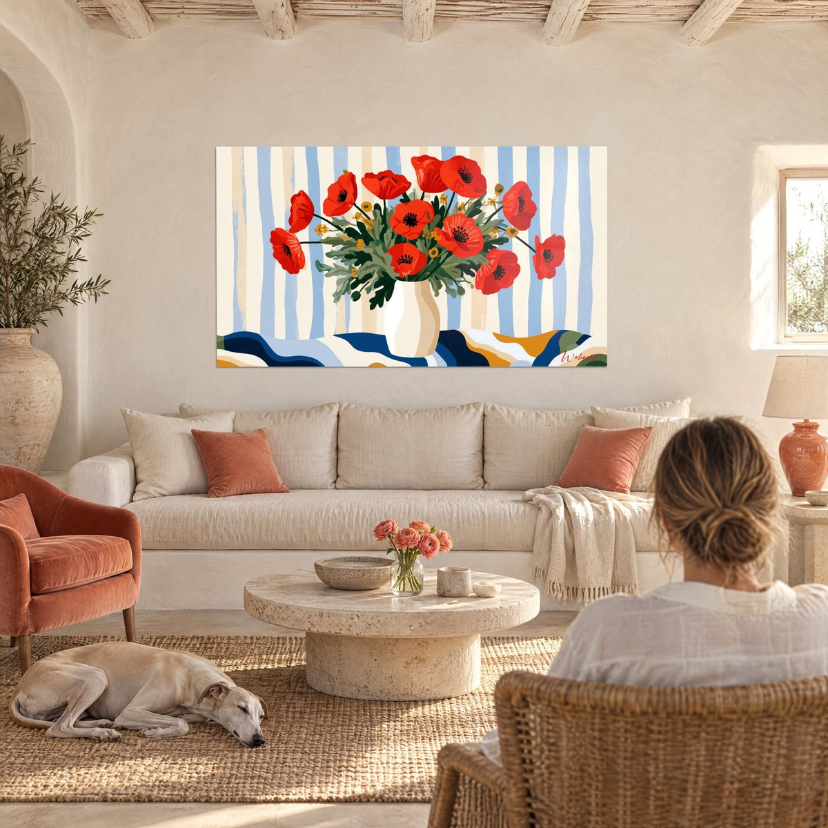 Tableau bouquet de pavots écarlates dans un vase ivoire, rayures bleues et crème, au-dessus d'un canapé dans un salon lumineux