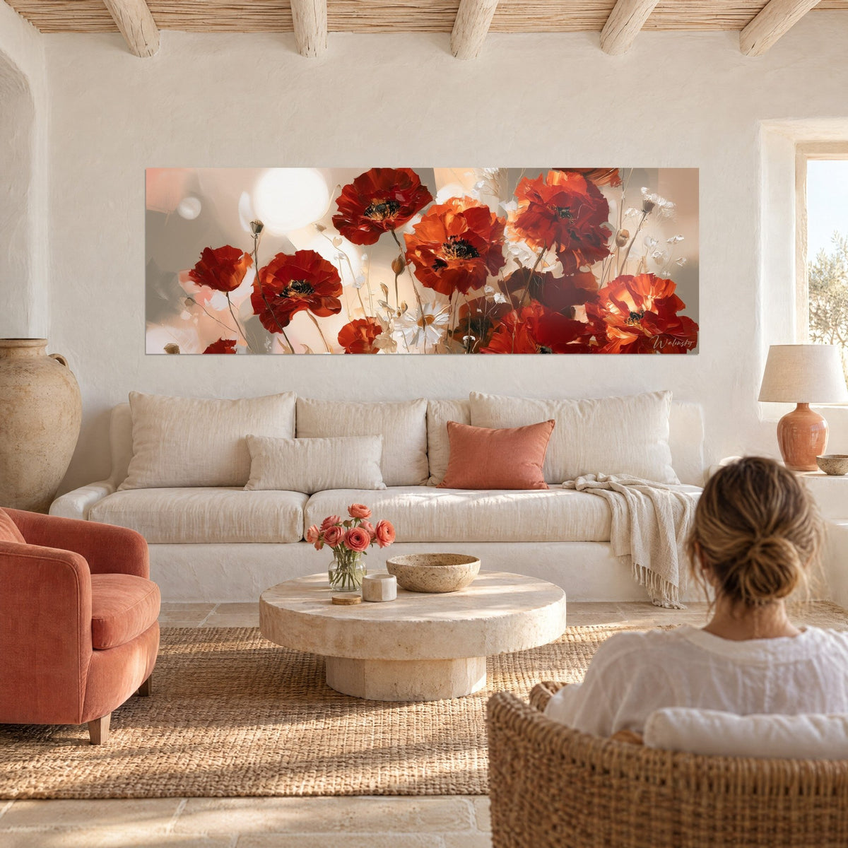 Quadro bouquet di papaveri scarlatti e arancioni, margherite bianche, alone beige, donna di spalle, sopra un divano in un soggiorno luminoso