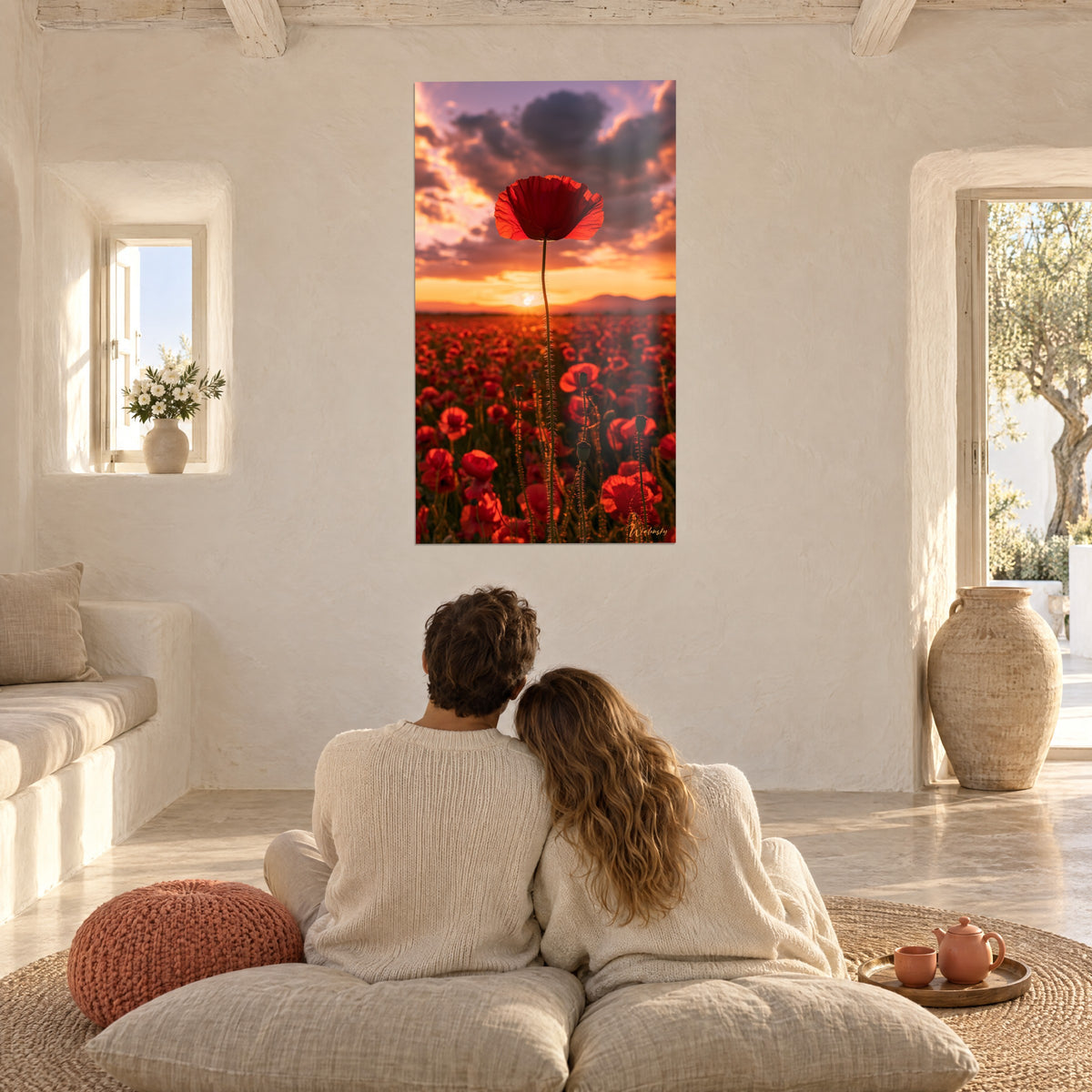 Quadro prato di papaveri rossi e tramonto arancione, nuvole viola, coppia abbracciata di spalle sui cuscini di fronte alla parete bianca