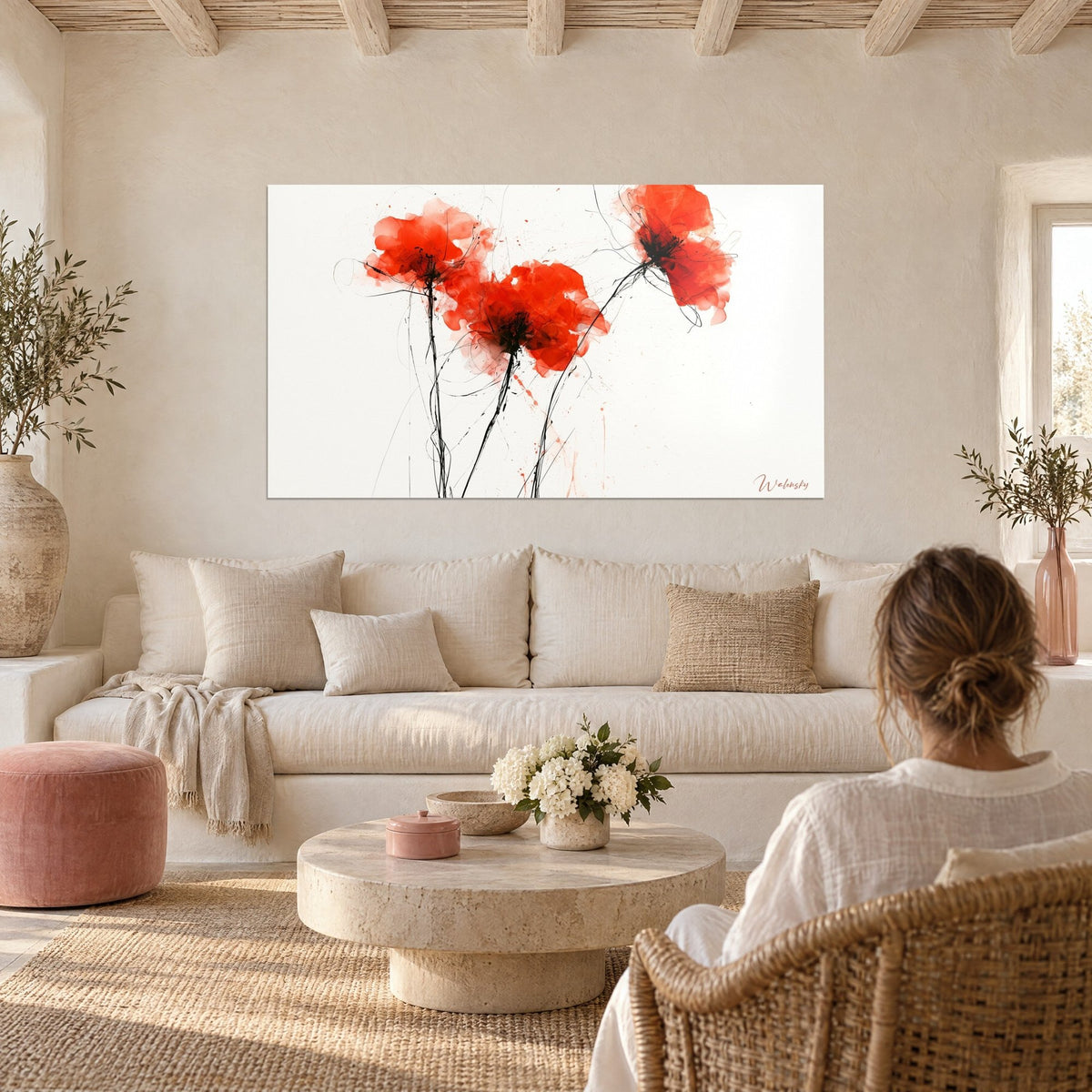 Tableau coquelicots écarlates et tiges d'encre noire sur fond blanc, deux personnes de dos, au-dessus d'un canapé dans un salon lumineux