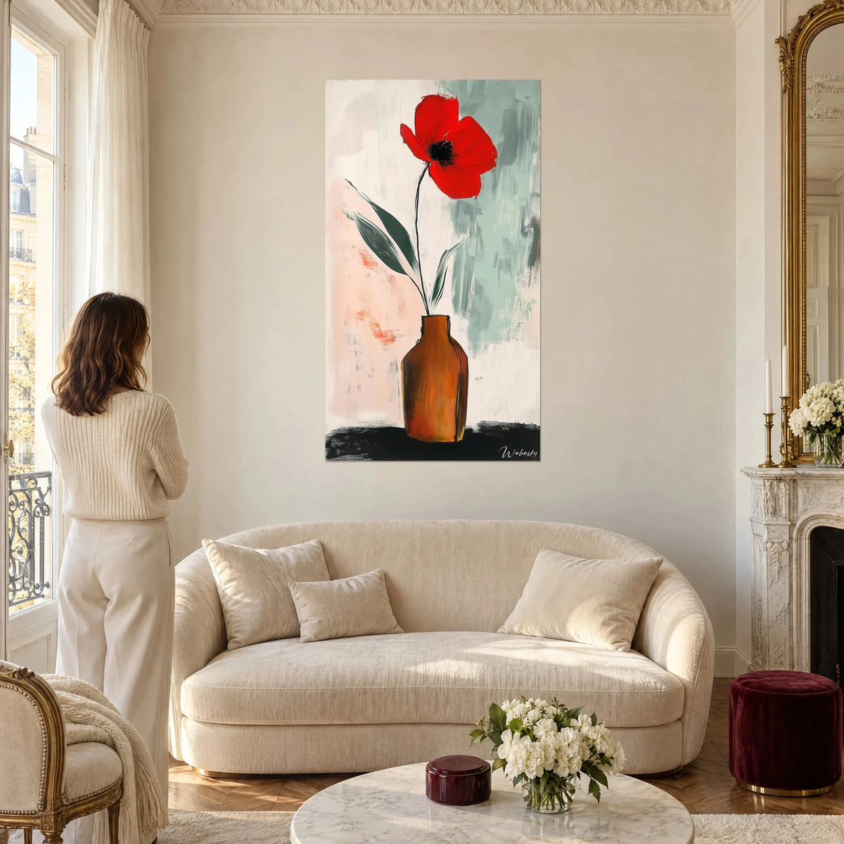 Tableau coquelicot rouge vif dans un vase brun orangé, fond rose pâle et vert sauge, au-dessus d'un canapé dans un salon lumineux