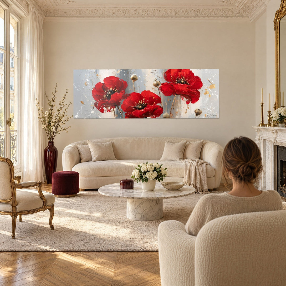Tableau coquelicots écarlates aux cœurs noirs piqués d'or sur fond gris perle, au-dessus d'un canapé dans un salon lumineux