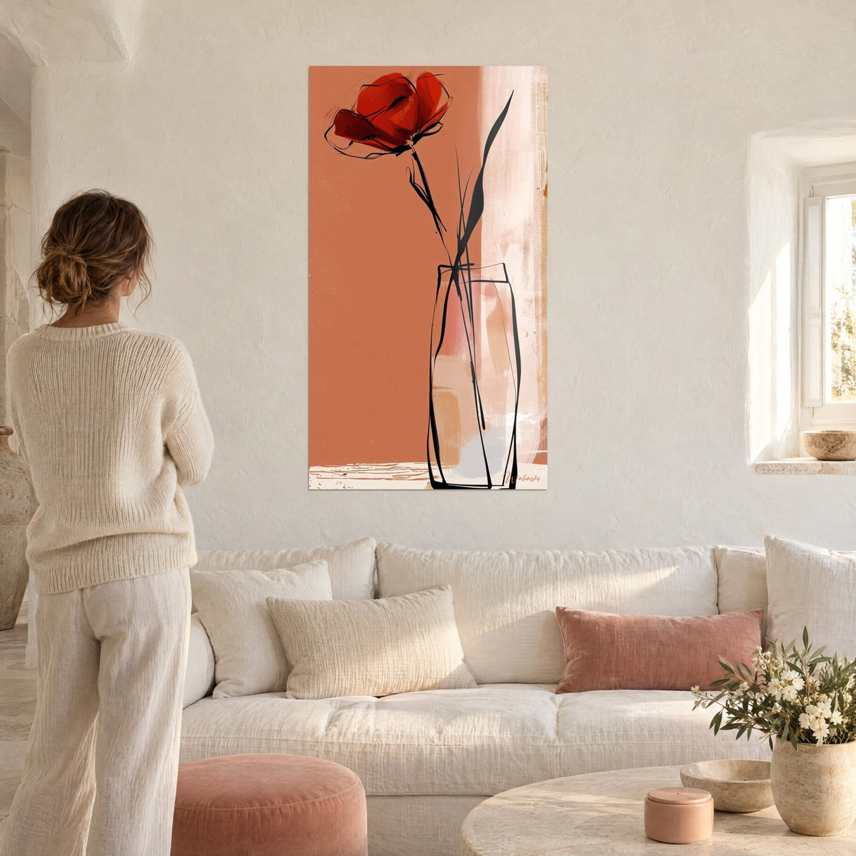 Cuadro amapola roja en un jarrón de cristal con trazos negros, fondo terracota, encima de un sofá en un salón luminoso