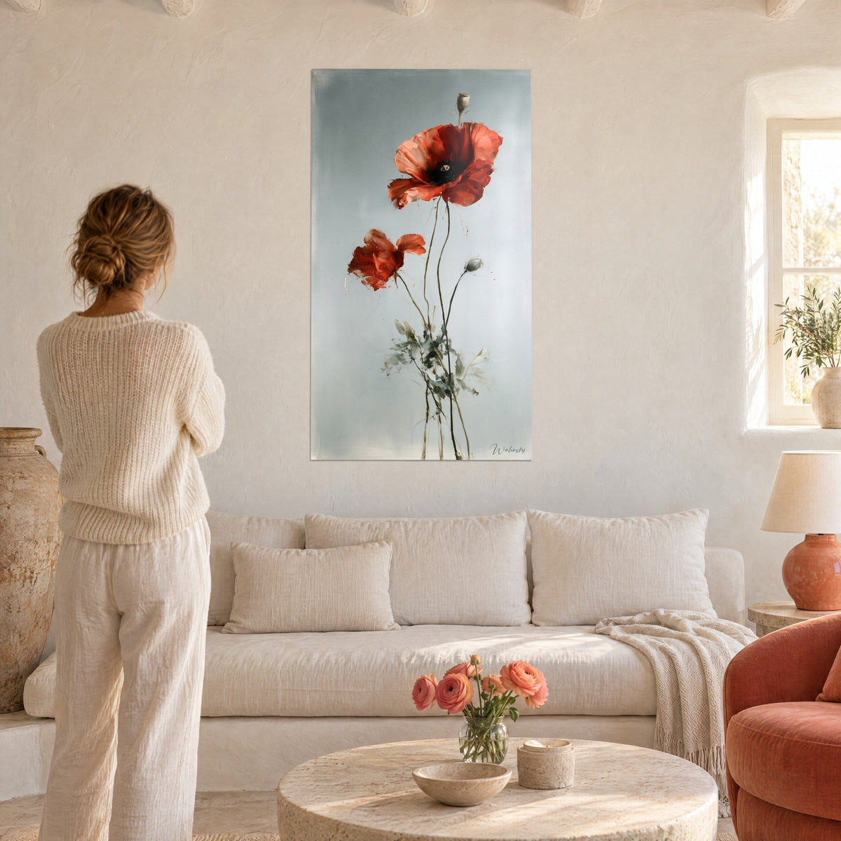 Tableau coquelicots rouges vermillon sur fond gris perle, tiges graciles, femme de dos au-dessus d'un canapé dans un salon lumineux