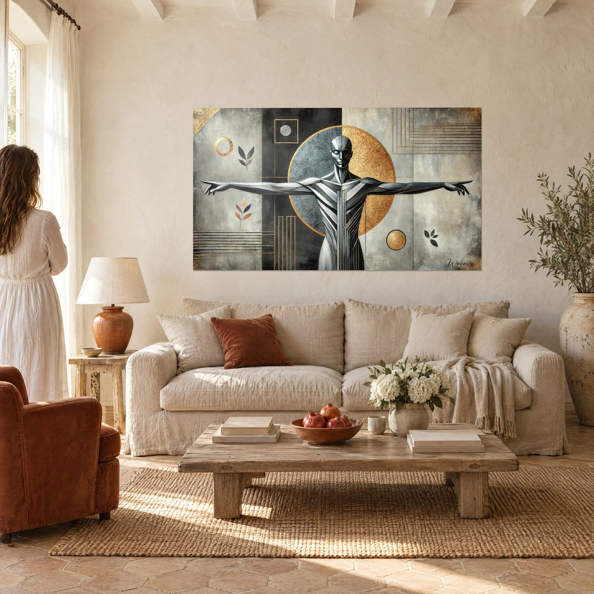 Cuadro silueta metálica con los brazos abiertos frente a un disco dorado y gris, fondo antracita, sobre un sofá en un salón luminoso