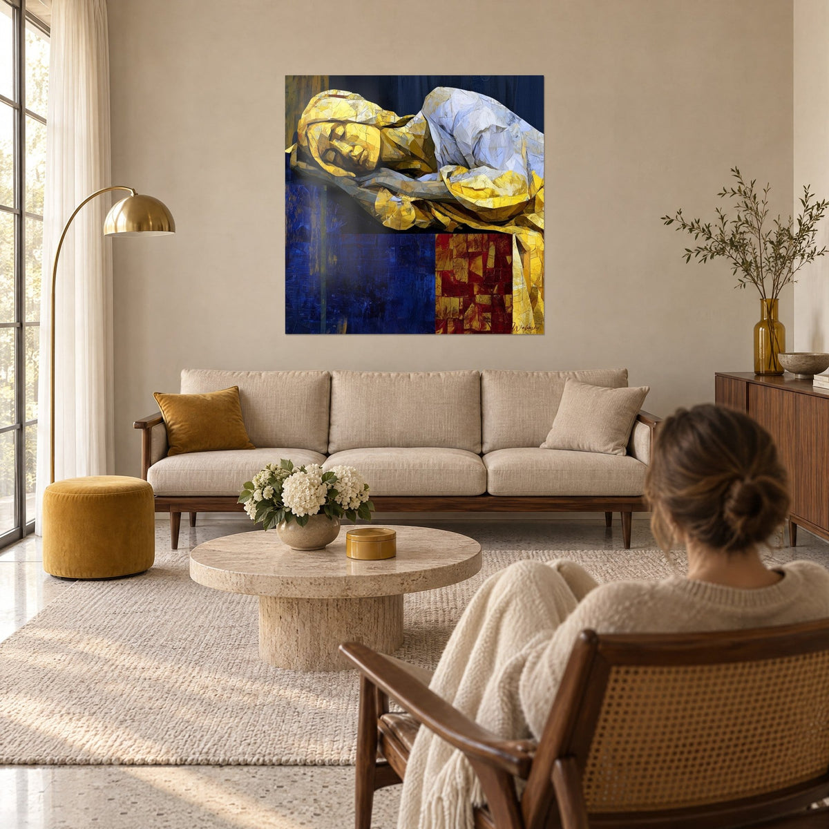 Tableau gisant doré aux éclats cubistes, drap blanc et fond bleu nuit, au-dessus d'un canapé dans un salon lumineux