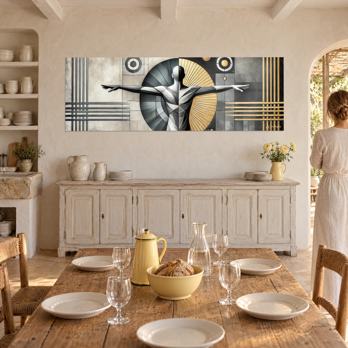 Tableau personnage épuré aux bras tendus, éventail doré contre fond gris béton, au-dessus d'un buffet blanc en Provence