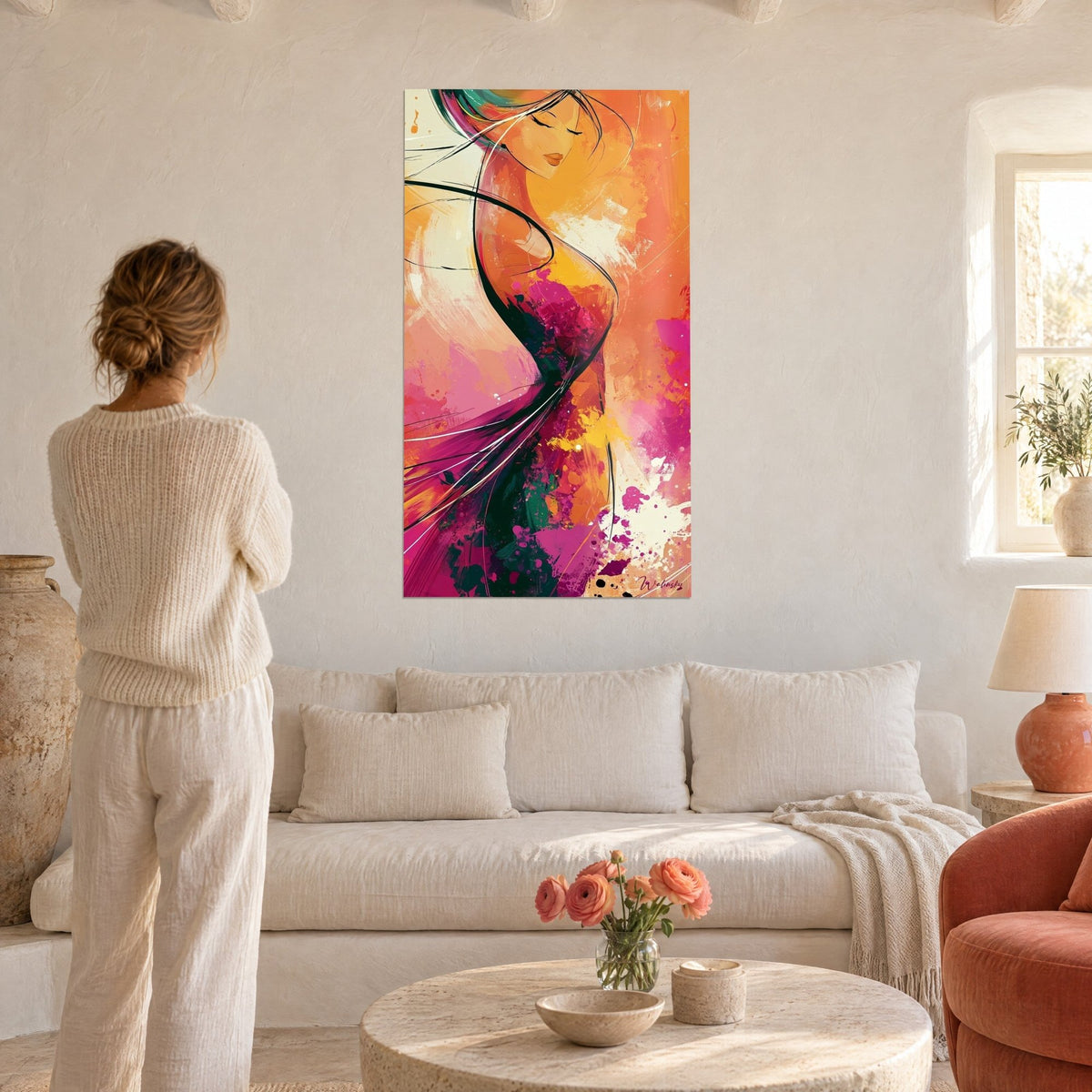 Tableau silhouette féminine aux cheveux ondulants, orange et magenta, au-dessus d'un canapé dans un salon lumineux