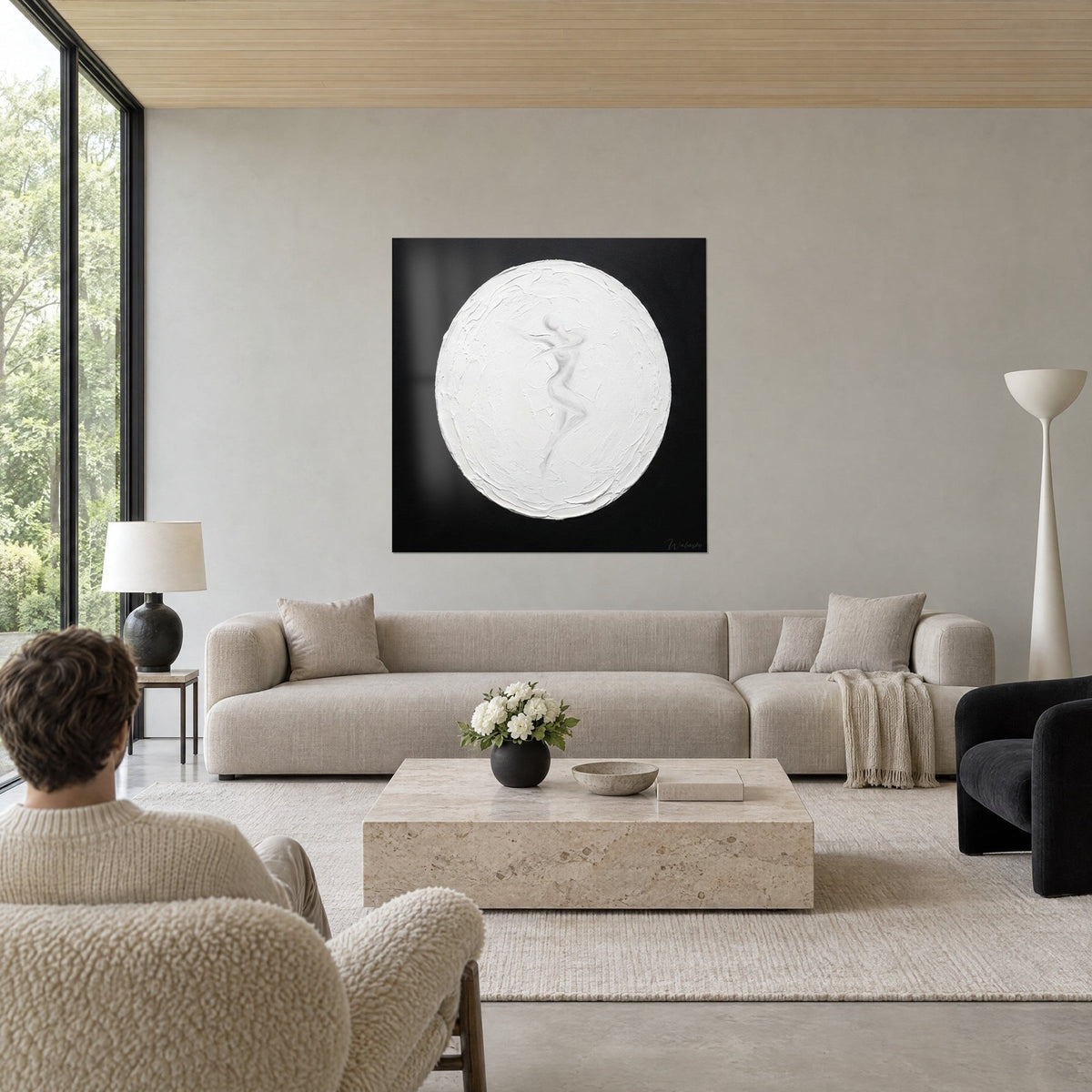 Quadro sagoma di donna che danza in rilievo bianco, spesso disco di stucco su fondo nero, sopra un divano in un soggiorno luminoso