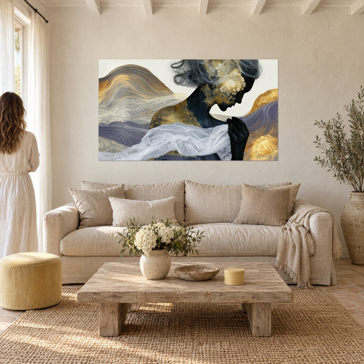 Quadro sagoma dorata inclinata, volute blu-oro e velo bianco, una donna di spalle, sopra un divano in un soggiorno luminoso