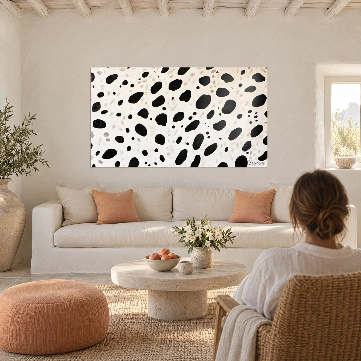 Gemälde mit schwarzen Dalmatiner-Flecken auf elfenbeinfarbenem Grund, über einem Sofa in einem hellen Wohnzimmer